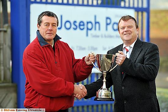 PUT IT THERE: Pete Beswick (left), chairman of Waterhead ARLFC, receives the Rugby Oldham Challenge Trophy from Iain Taylor. 
