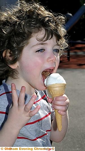 What a difference a week makes... Patrick Clure ( 3 yrs ) gets stuck into his ice cream in the park in Uppermill. 
