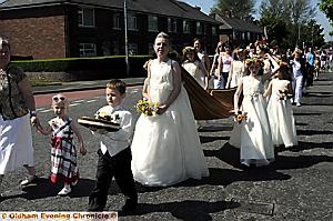 STRIDING OUT... St Paul’s Rose Queen, Lucy Mary Lingard with her retinue in Royton 

