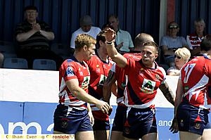 WELL DONE, MATE: John Clough gets a pat on the head from Danny Whitmore after scoring Oldham’s second try (right). 