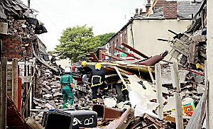 DEVASTATION . . . rescue crews sift through the rubble of the houses torn 