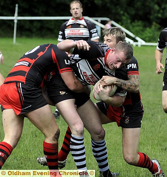 THAT’S MY BALL... Jimmy Rogers, of Saddleworth Rangers, is held by two Leigh East players in the Premier Division clash. THAT’S MY BALL... Jimmy Rogers, of Saddleworth Rangers, is held by two Leigh East players in the Premier Division clash.