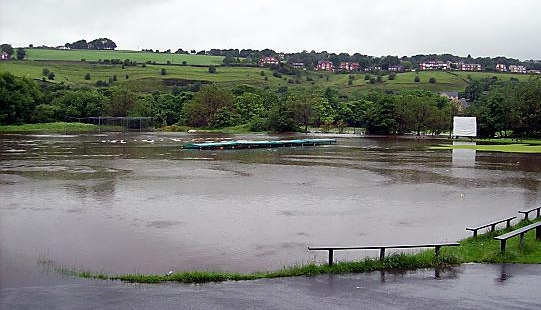 WATER, WATER, EVERYWHERE: the Saddleworth outfield last Friday after the River Tame burst its banks behind the ground at Well-i-Hole. WATER, WATER, EVERYWHERE: the Saddleworth outfield last Friday after the River Tame burst its banks behind the ground at Well-i-Hole.