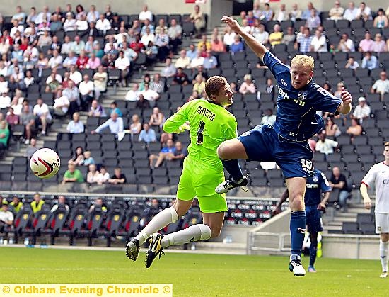 Simpson tangles unsuccessfully with MK Dons goalkeeper David Martin 