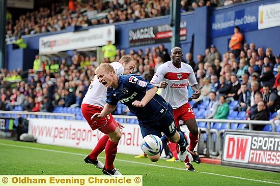 ROBBIE Simpson is sent tumbling under a Stevenage challenge. 
