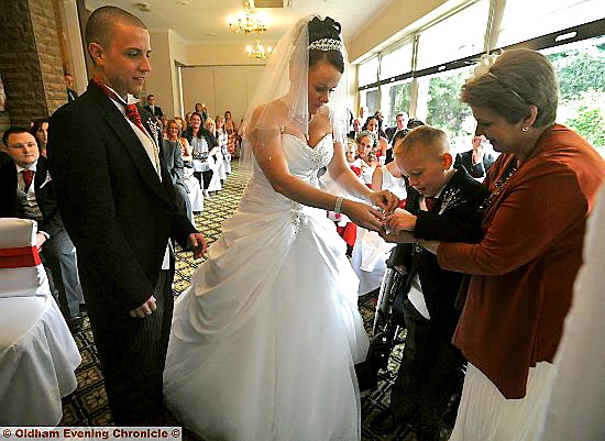 MAGIC moment: Adam passes the rings to mum Anita watched by bridegroom Adam Claxton 
