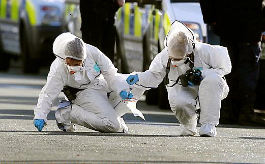 ON the scene . . . police forensic officers look for evidence 