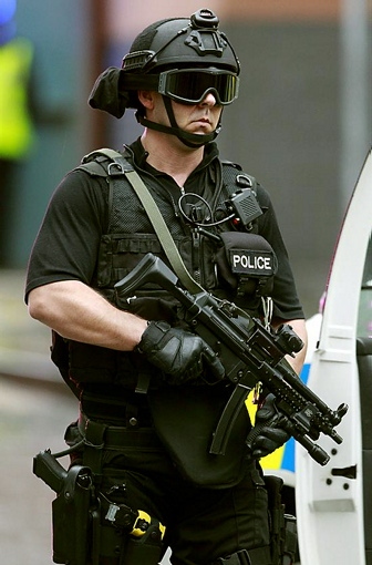 AN armed police officer guards the streets near the court building. 