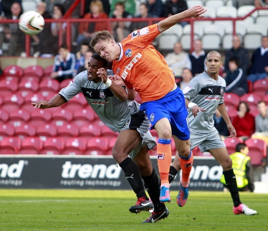 AIR RAID . . . Matt Smith beats Leon Legge to a header. 
