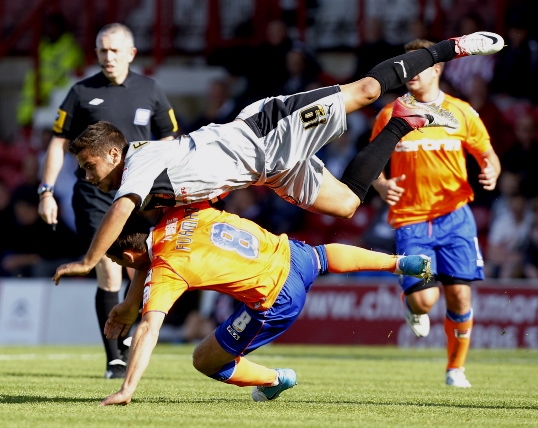 COLLISION COURSE . . . Dean Furman is bundled to the ground as Harry Forrester produced a committed challenge for Brentford. 