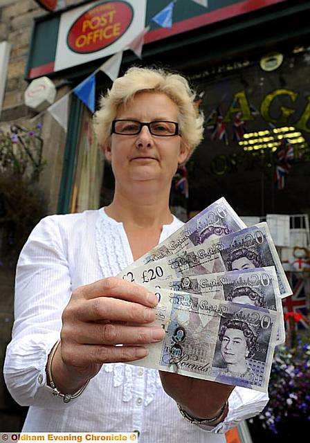 TAKE note: staff member at Uppermill Post Office, Karen Kilgannon, with the forgeries
TAKE note: staff member at Uppermill Post Office, Karen Kilgannon, with the forgeries