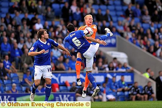 UP AND AT ’EM . . . Athletic forward Robbie Simpson (right) and Chesterfield defender Sam Hird battle for the ball. 