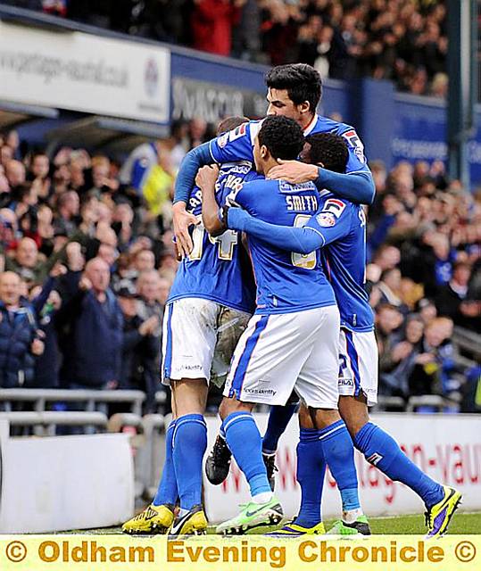 Latics players mob their goal-scoring hero. 