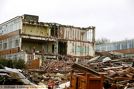 COMING down . . . the building is reduced to rubble  

