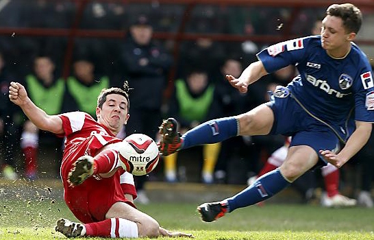 GETTING STUCK IN . . . Athletic youngster Danny Gosset (right) challenges Leyton Orient’s Lloyd James at Brisbane Road on Saturday. 
