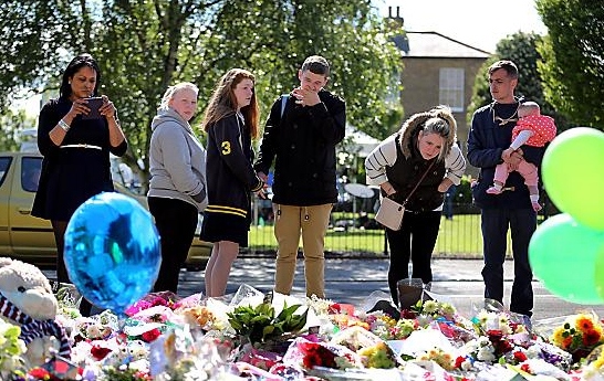 A man weeps outside the Royal Artillery Barracks in Woolwich as he looks at floral tributes left following the attack in Woolwich  

