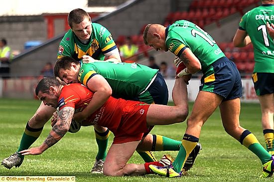 OLDHAM trio Adam Files (left), Phil Joy and Kenny Hughes make sure Stuart Reardon goes to ground at the Racecourse. 