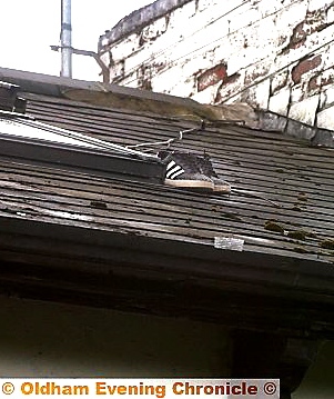 A PAIR of trainers next to the skylight on the roof from which the victim fell  

