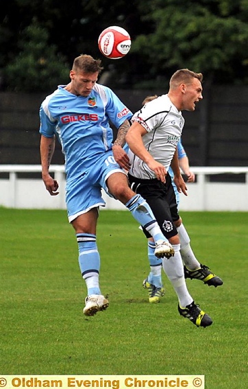 AIR RAID . . . Mossley defender Kyle McGonigle (white shirt) battles for aerial supremacy during last Saturday’s 3-1 defeat to Kendal Town. 
