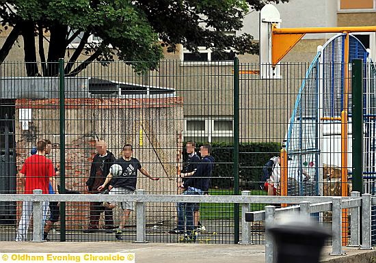 YOUTHS hanging out at the outdoor play area in Newbury Walk, Chadderton  

