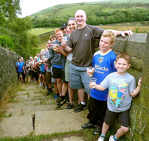 THIRSTY work . . . Bryn Hughes and his supporters raise a glass at a fundraising trek at Marsden flight, near Butterley Reservoir 
