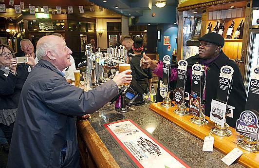 BLESS you Archbishop: the Archbishop of York the Rt Rev John Sentamu looks after thirsty regulars as he pulls a pint of Bishops Finger ale for Doug Watts at Oldham’s Up Steps Inn on Yorkshire Street. 