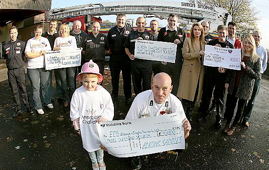 FIREFIGHTERS present the cheques to their chosen charities. In front is Annabelle Griffin (5) accepting £3,000 for EDS