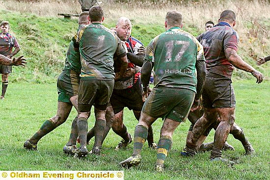 surrounded: Higginshaw’s Gareth Bradley has nowhere to go in the face of a formidable Golborne defence.