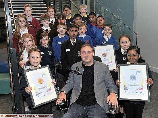 Pictured are (from the left) Sam Yates, from Christ Church, Chadderton, with his gold award, local campaigner Andy Walker, Maddison Walker, of Oldham Academy North, with her bronze award, and Kainath Nafeef, of Broadfield School, with her silver award.