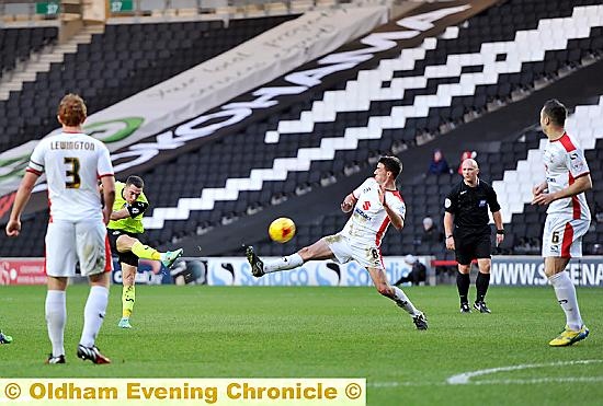 Mike Jones has a rare shot at the MK Dons’ goal