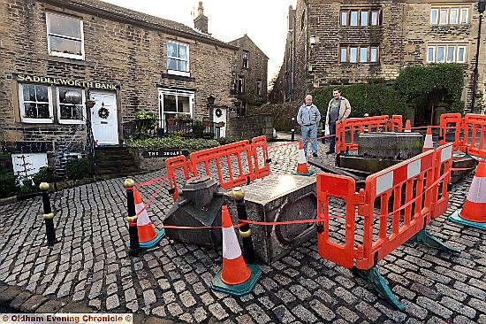 Dobcross residents look at the Ramsden Memorial Fountain in the village square which was demolished by a runaway van