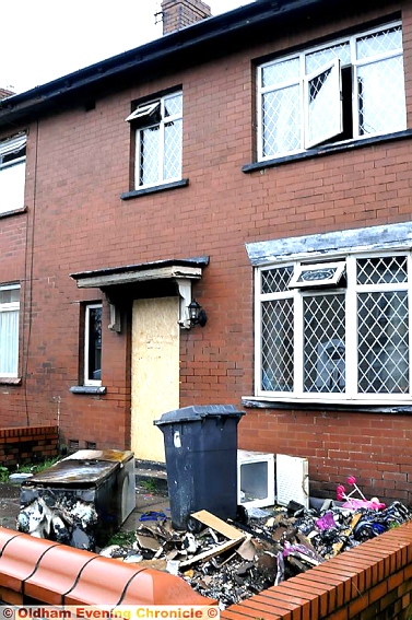 The house today: door boarded up, windows blackened 
