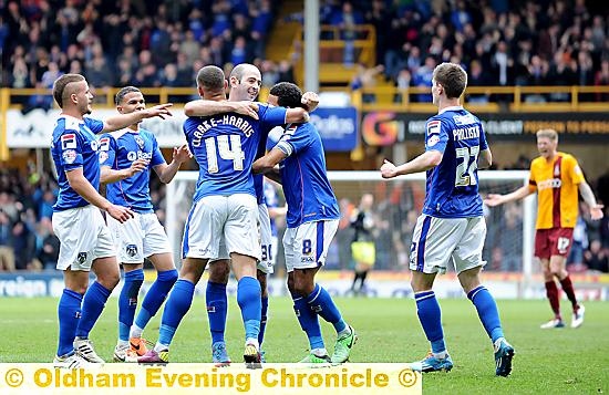 WELL DONE, MATE: Jonson Clarke-Harris is mobbed by his team-mates after scoring the first of his two goals at Valley Parade. 