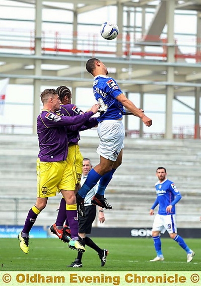 RISING TO THE CHALLENGE: Jonson Clarke-Harris wins the ball in the air for Athletic to a backdrop of the new stand. 