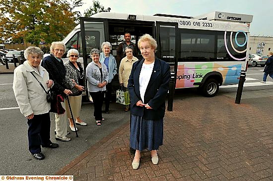 CARING . . . the driver of the Shopping Link service helps people off the bus to get their shopping