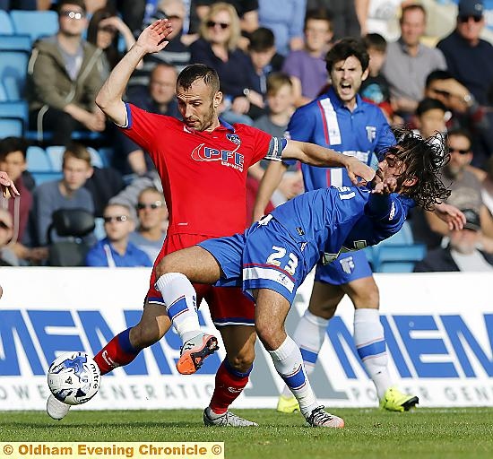 Luke Kelly battles for possession with Bradley Dack.
