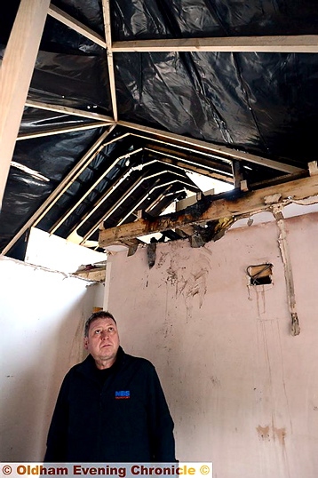 EXTENSIVE damage . . . Brian Howarth surveys the damage to his home