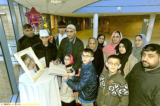 Family members, including dad Nasir (holding the book of condolences) and brothers Wajid (front left) and Amir, read the tributes to Rashid