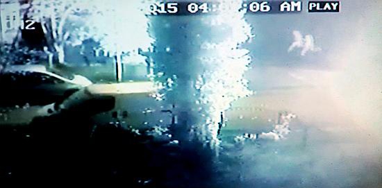 figures (top right) are seen running away as the car in the foreground bursts into flames