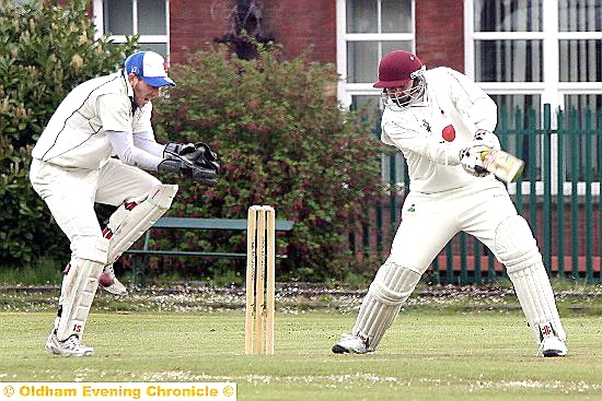 TAKE THAT: Heyside wicketkeeper Matthew Chadwick collects the ball as Werneth skipper Ian Dronsfield attempts a cut shot.

