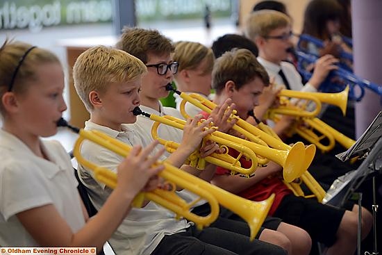 Primary school pupils perform in a brass band concert (with plastic instruments) at Mossley Hollins High School.