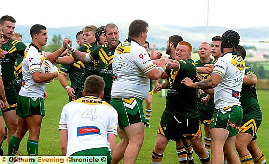 FLASHPOINT . . . Mick Fogerty (centre) tries to act as peacemaker as Oldham St Anne’s and Askam players square-up at Higginshaw Road.