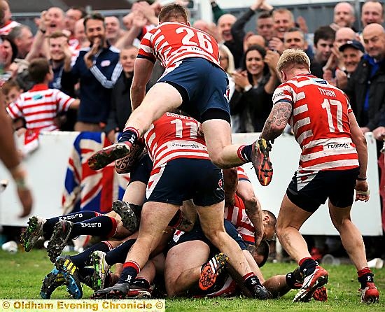 Adam Clay is mobbed by his team mates after scoring his side’s fifth try of the afternoon. 