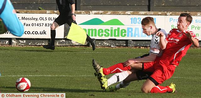 SLIDING TACKLE . . . Mossley's Jonah Gosling (white strip) stretches for a challenge.