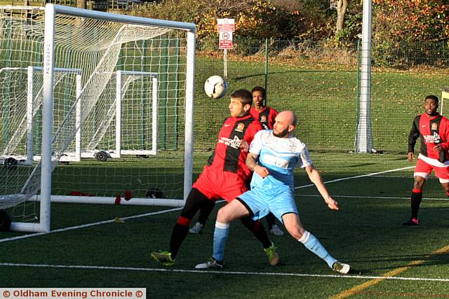 CLOSE . . . Heyside’s Jordan Hindley (blue shirt) puts pressure on Hollinwood
