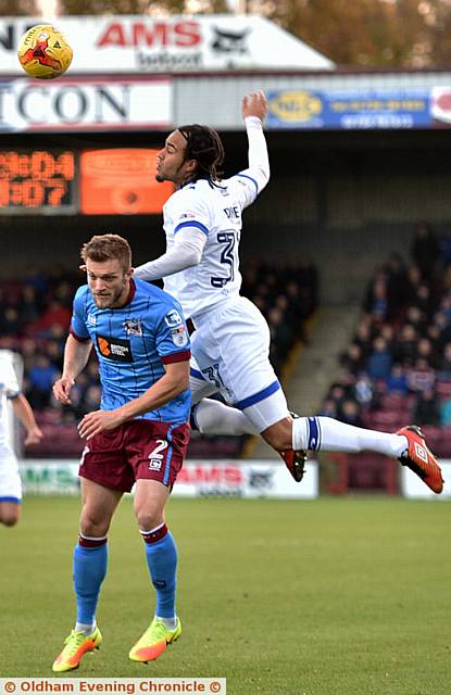 UP HIGH ... Charles Dunne rises above his Scunthorpe rival