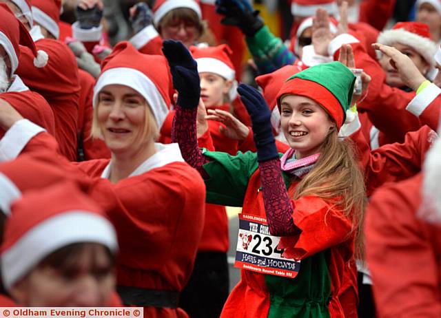 A QUICK swing of the arms as the Santas warm up for the dash. Pictures by TIM BRADLEY