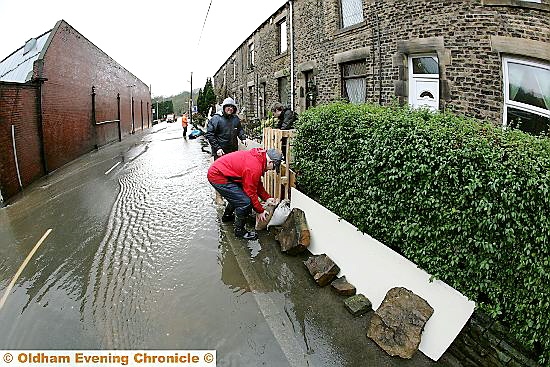 STEM the tide: residents battle against the elements in Delph New Road, Delph, as the floods threaten to take hold STEM the tide: residents battle against the elements in Delph New Road, Delph, as the floods threaten to take hold