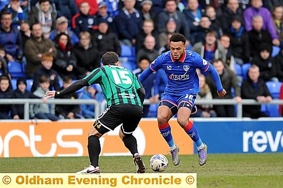 EYE ON THE BALL . . . Aaron Amadi-Holloway takes on Rochdale’s Niall Canavan. Loan forward relishing his Latics lease of life