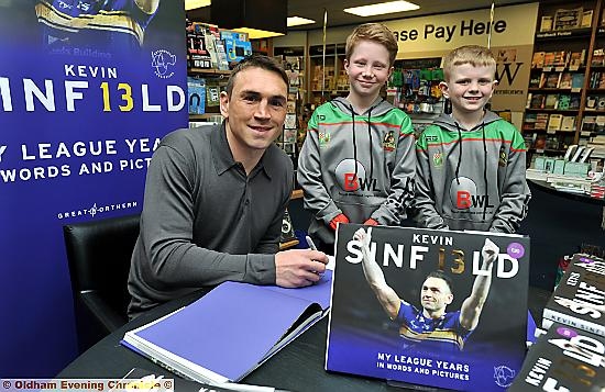 STAR SIGNING: Kevin Sinfield pens a message in his new book at Waterstones in Spindles, flanked by young fans Peter White and Buckley Kershaw, both of whom play for the ex-Leeds Rhinos star’s former amateur club Waterhead at under-10s level. STAR SIGNING: Kevin Sinfield pens a message in his new book at Waterstones in Spindles, flanked by young fans Peter White and Buckley Kershaw, both of whom play for the ex-Leeds Rhinos star’s former amateur club Waterhead at under-10s level.